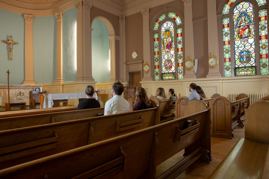 People sit in the pews within the chapel at St. Joseph's Hospital.