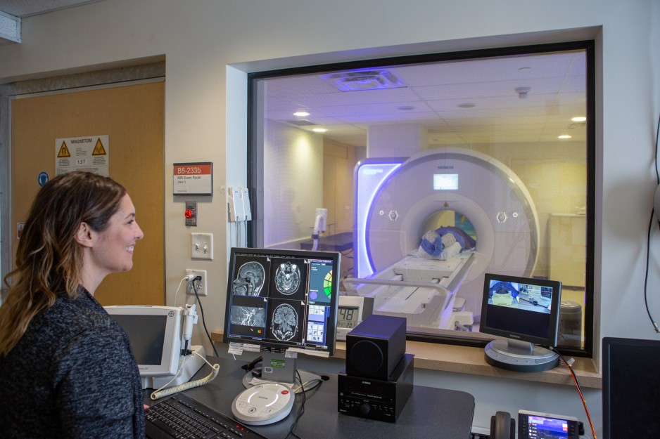 An MRI technician watches as a patient undergoes an MRI.