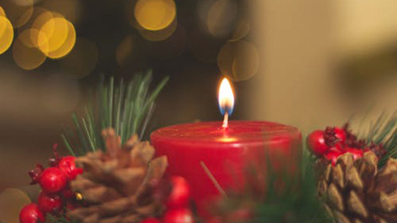 Image of a Christmas candle surrounded by a wreath.