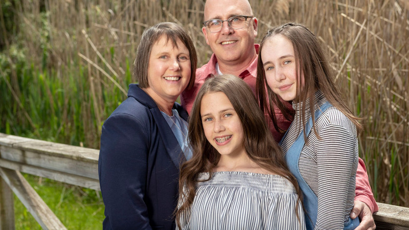 a family photo of a wife, husband and their two daughters