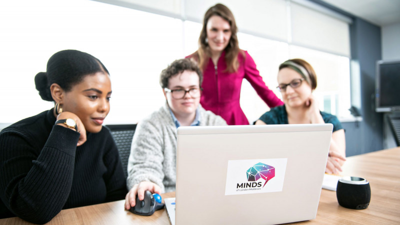 group of people gather around a computer
