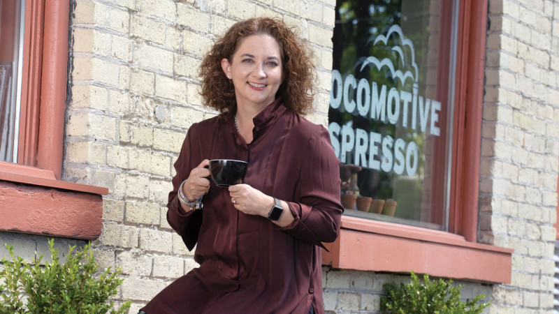 woman drinking coffee in front of a store