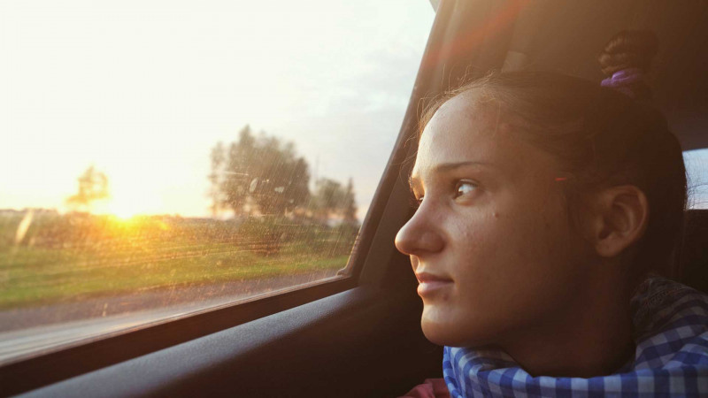 young woman in car looking out the window