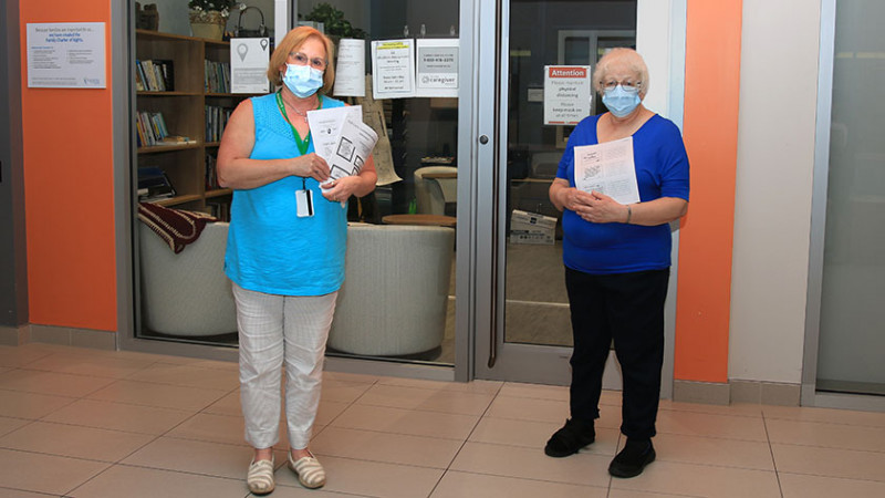 Laurel Lamarre and Chris Boyd wearing masks standing in front of the Family Education Resource Centre at Parkwood Institute
