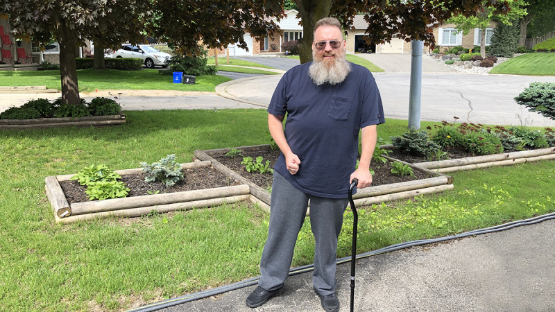 Stroke survivor Roger Oatman standing with a cane