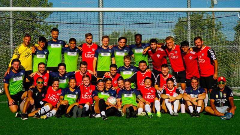 Participants at Kicks for Strength event pose underneath soccer net