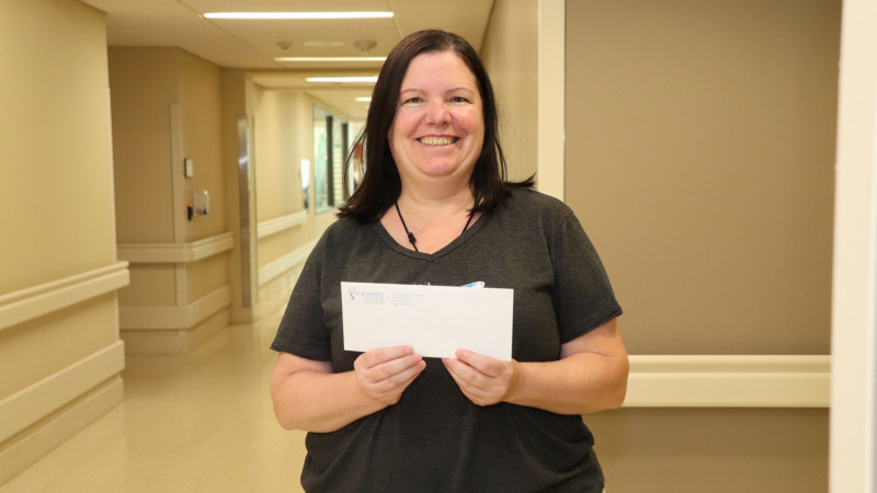 Tara Smith holds up a cheque