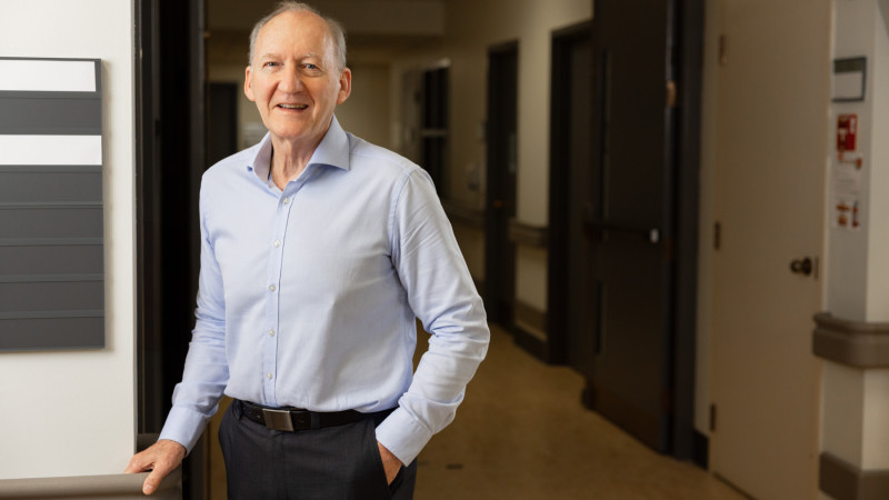 Dr. Borrie leaning against a railing in a hallway