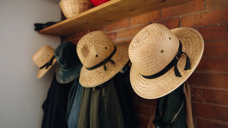 jackets and straw hats hanging on hooks