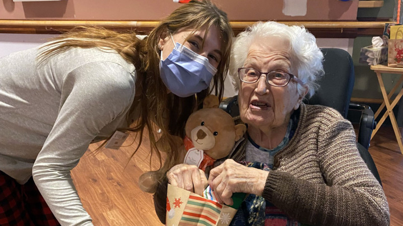 Care provider poses with Mount Hope resident holding gift bag