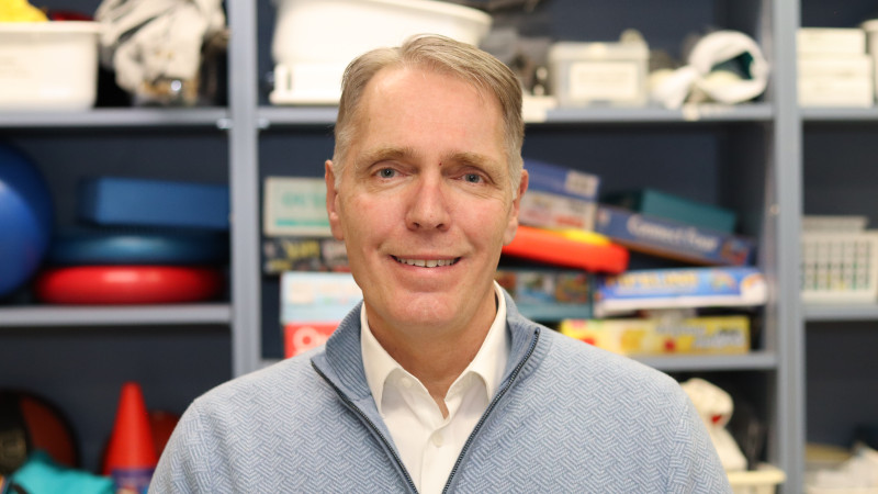 Man smiles in front of gym equipment