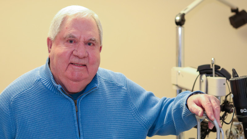 Brian stands next to the eye examination equipment