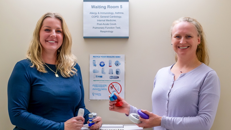 two staff members holding inhalers