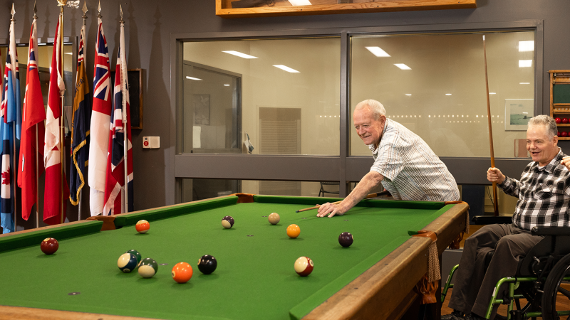Two veterans playing pool at Parkwood Institute