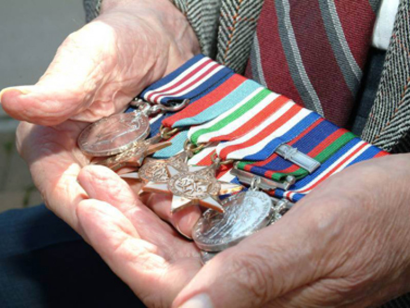 Veteran holding war metals in hands