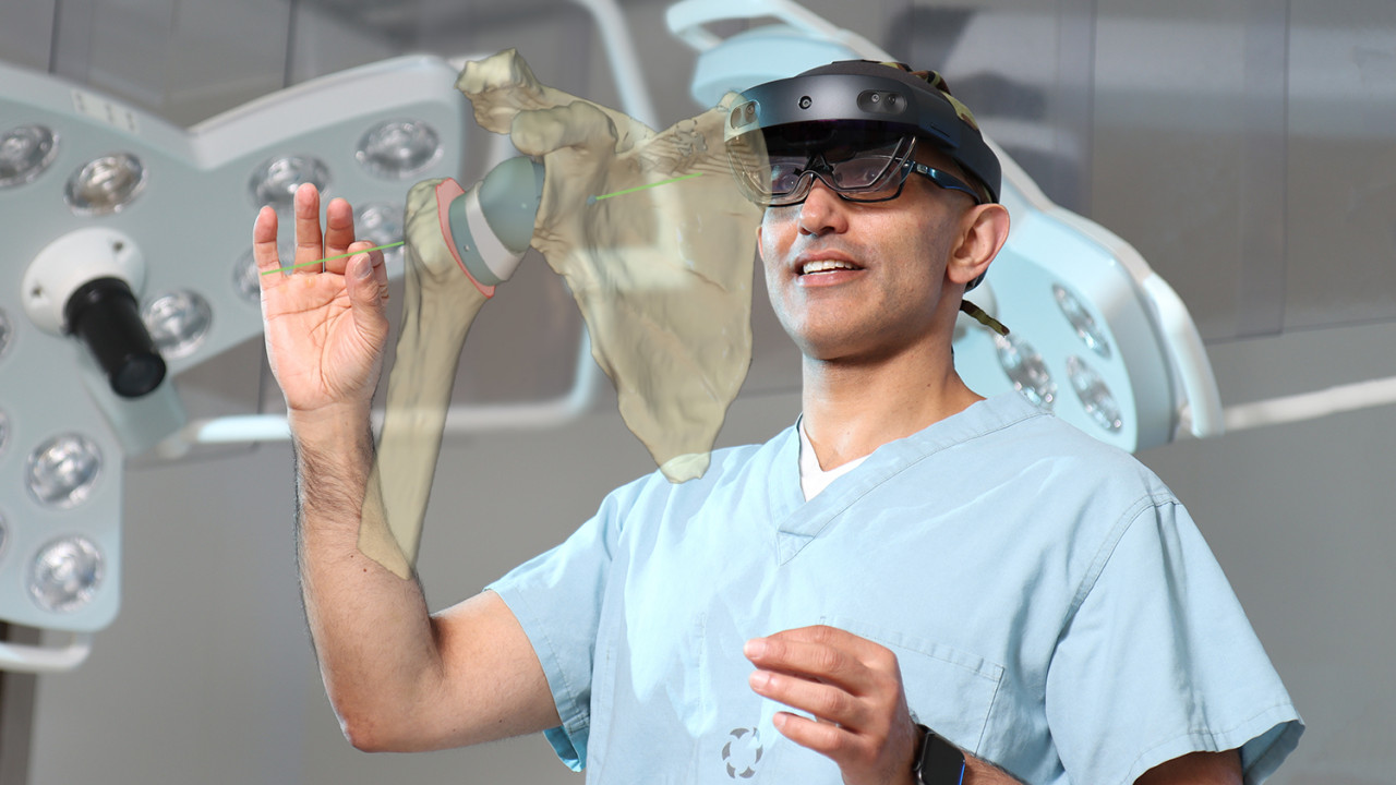 Dr. George Athwal wearing a HoloLens2 headset, viewing a hologram of a shoulder joint