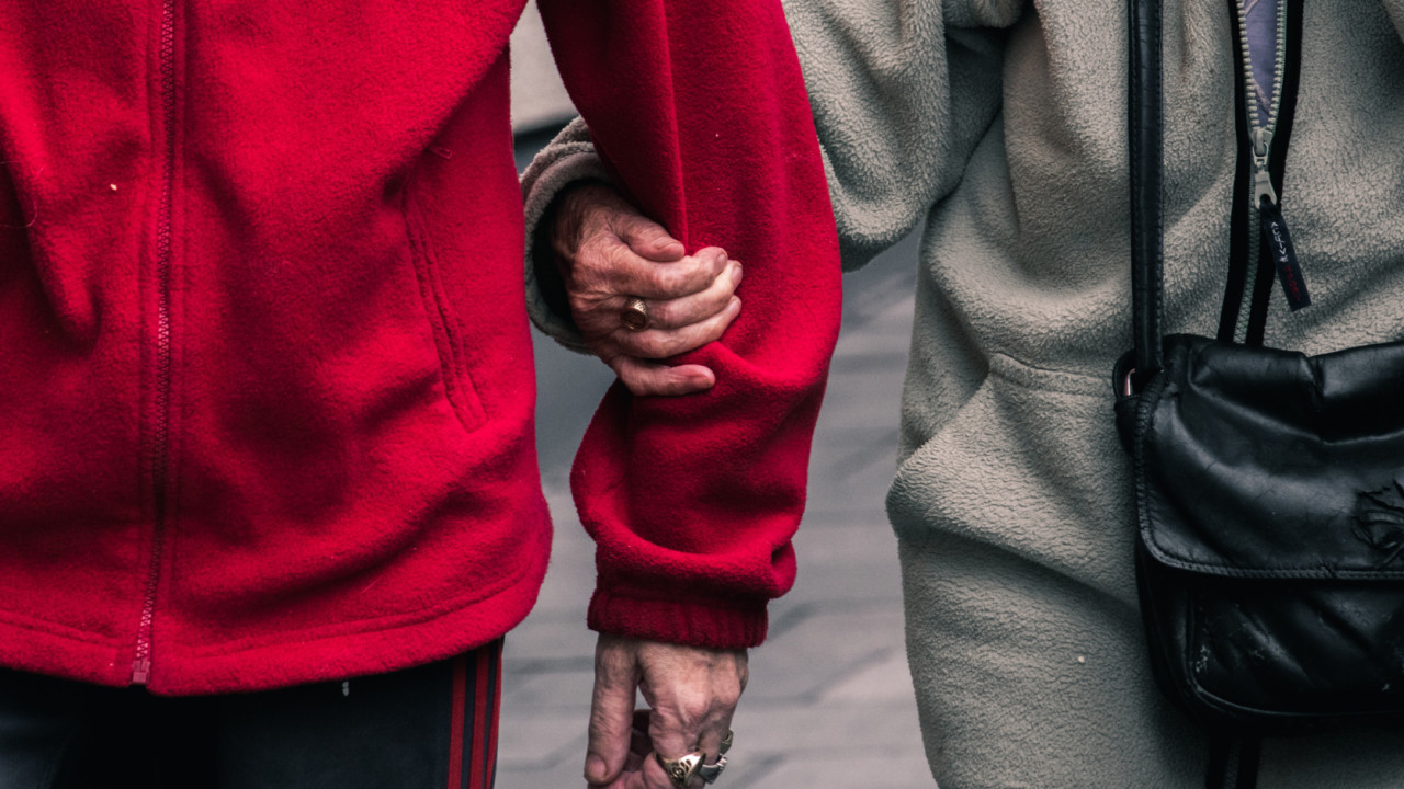 elderly couple holding hands