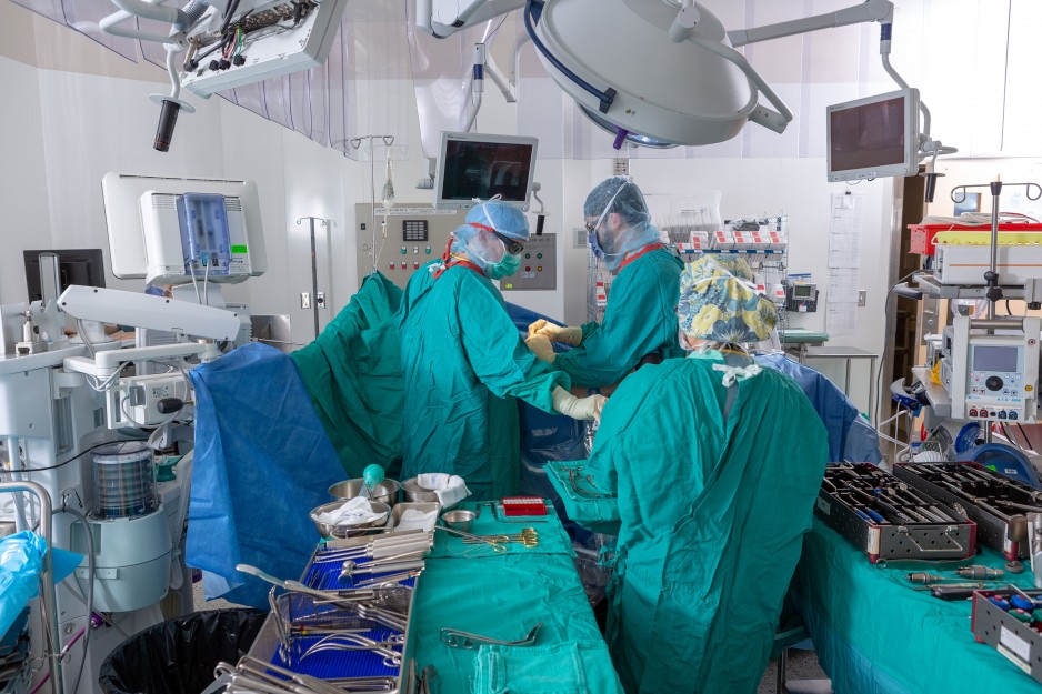 doctors perform surgery on patient in the operating room