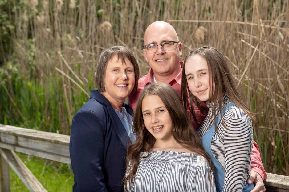 a family photo of a wife, husband and their two daughters