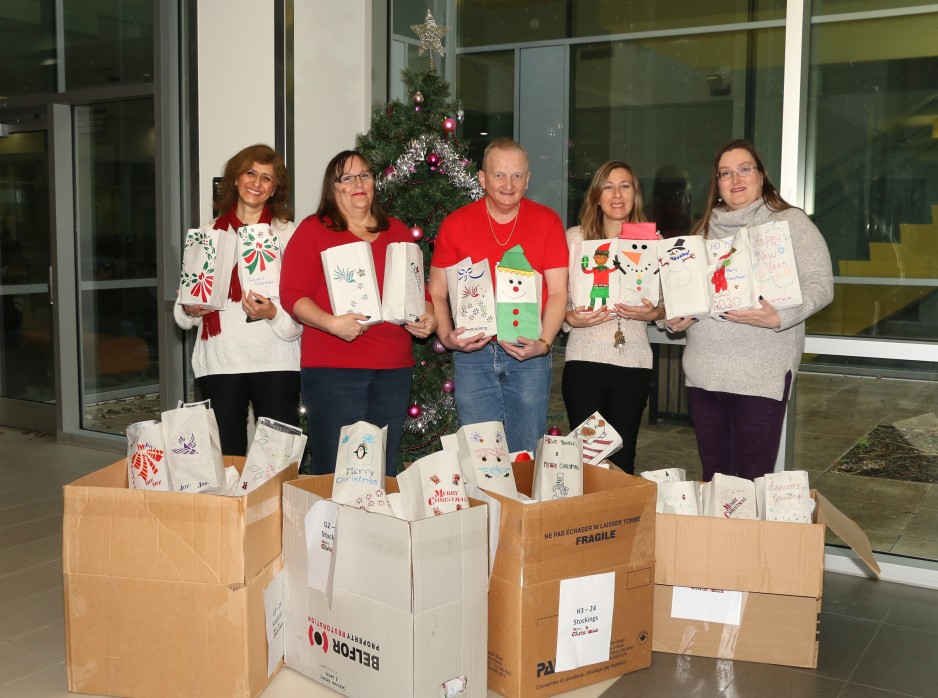 Members of the St. Joseph's team pose for a photo holding stockings they arranged for Christmas delivery.