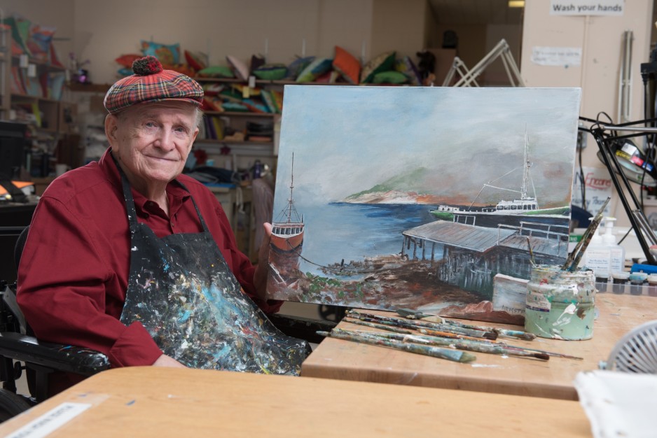 Bob Armstrong with his painting of a ship in a harbour