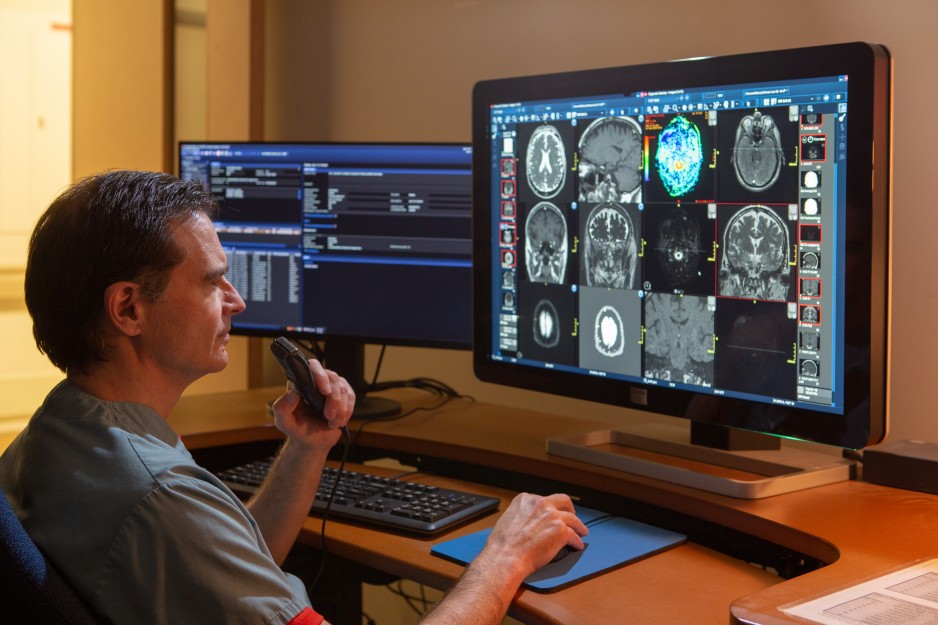 A radiologist examines patient results on his computer.