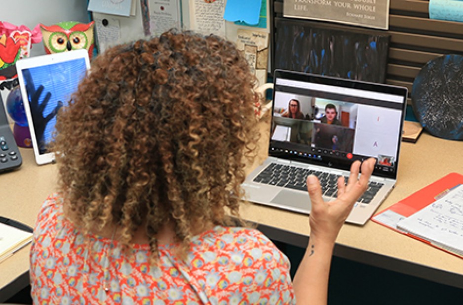 Female in front of laptop gesticulating with her hands