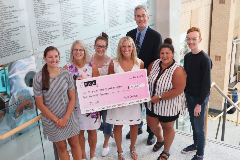 group of people hold up a large cheque