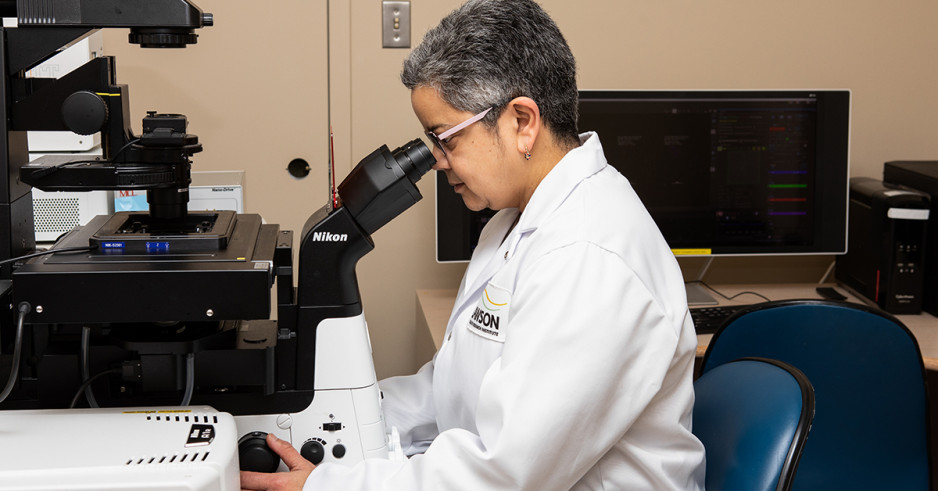 Scientist looking through a confocal microscope