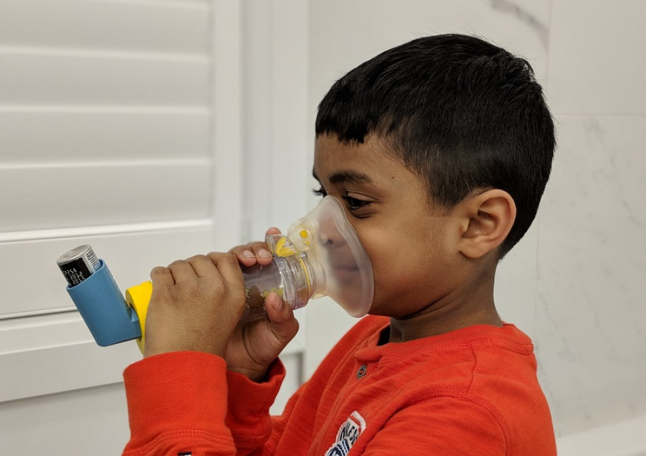 boy breathing into an asthma inhaler