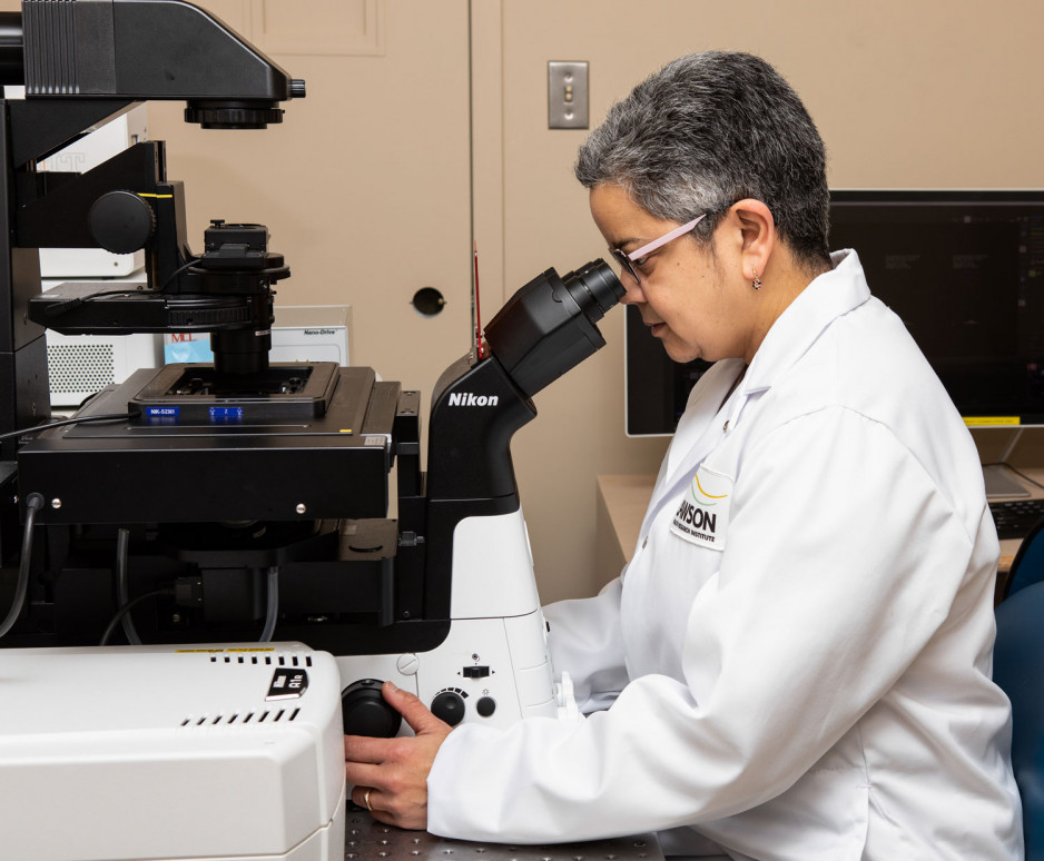A scientist looking through a microscope