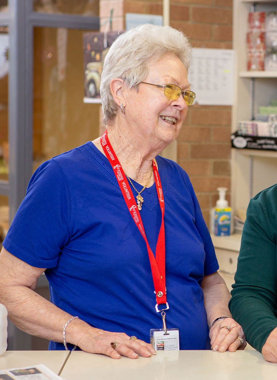 Marilyn Smith standing at the counter of the store where she volunteers