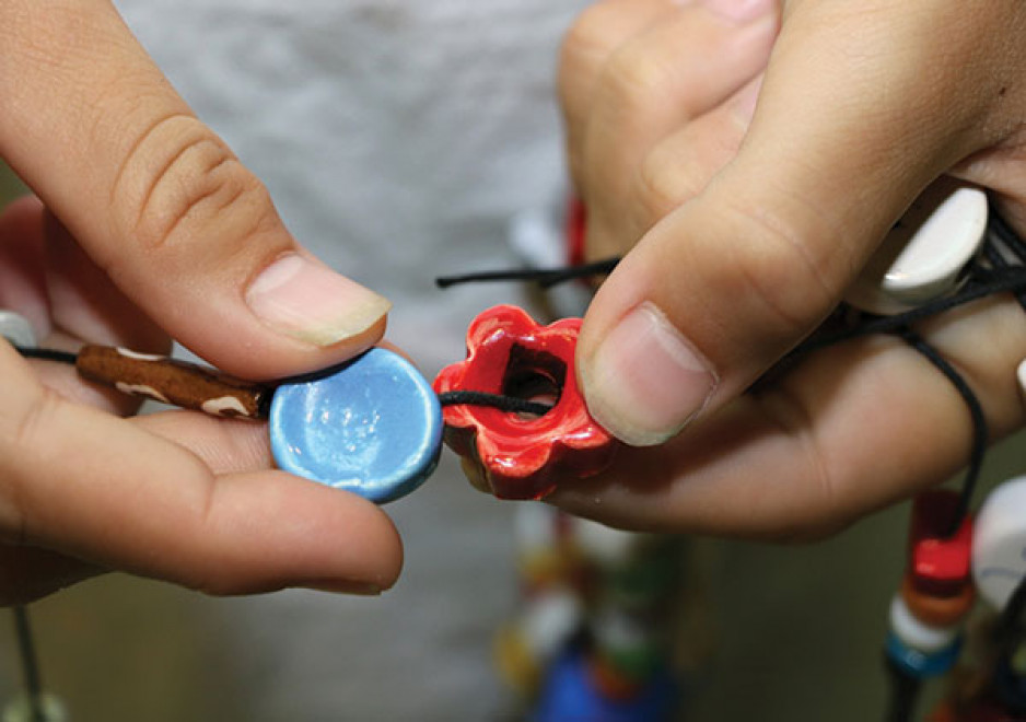 two ceramic bravery beads, one blue, on resembling a poppy 