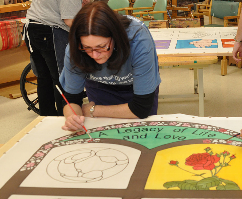 a woman working on a stained glass image