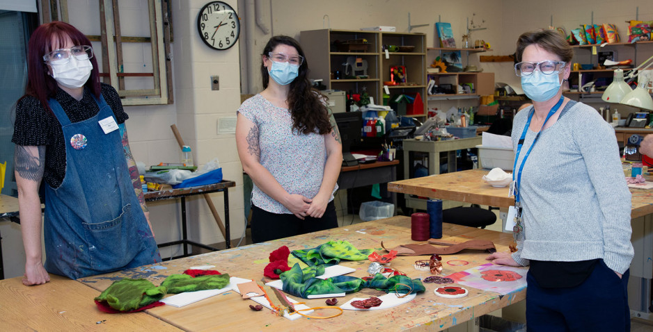 Art instructors Kim Smith, Rachel Woolmore-Goodwin and Beverly McNaughton standing at a table in the arts studio