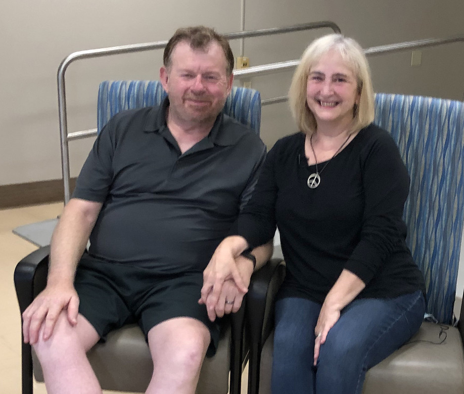Paul and Brenda holding hands, sitting in waiting room at Parkwood Institute