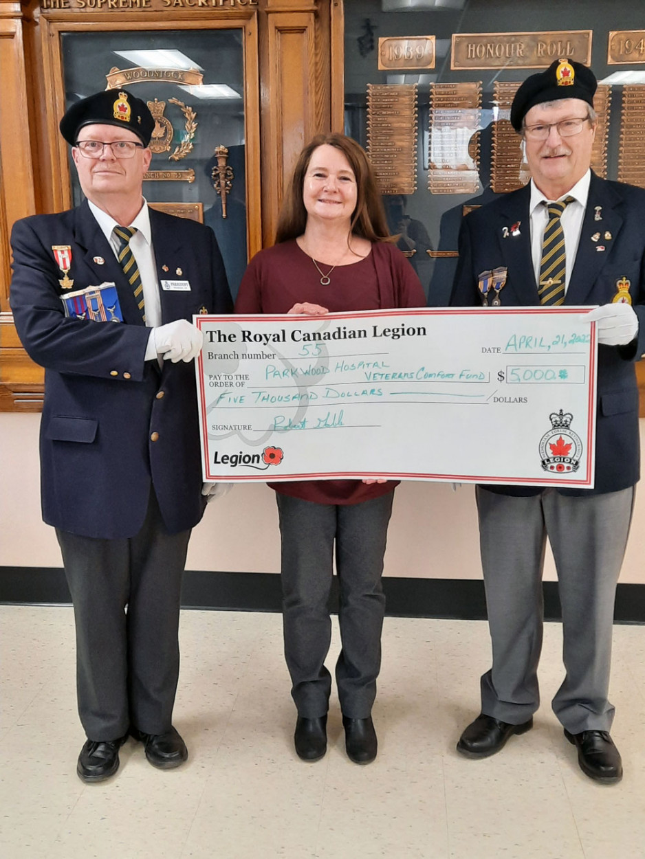 group of three people hold up a big vanity cheque