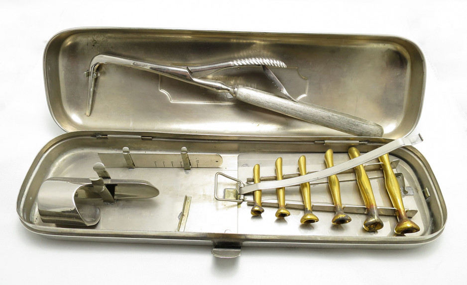 a set of historical medical tools used for intubation, all placed in a metal box