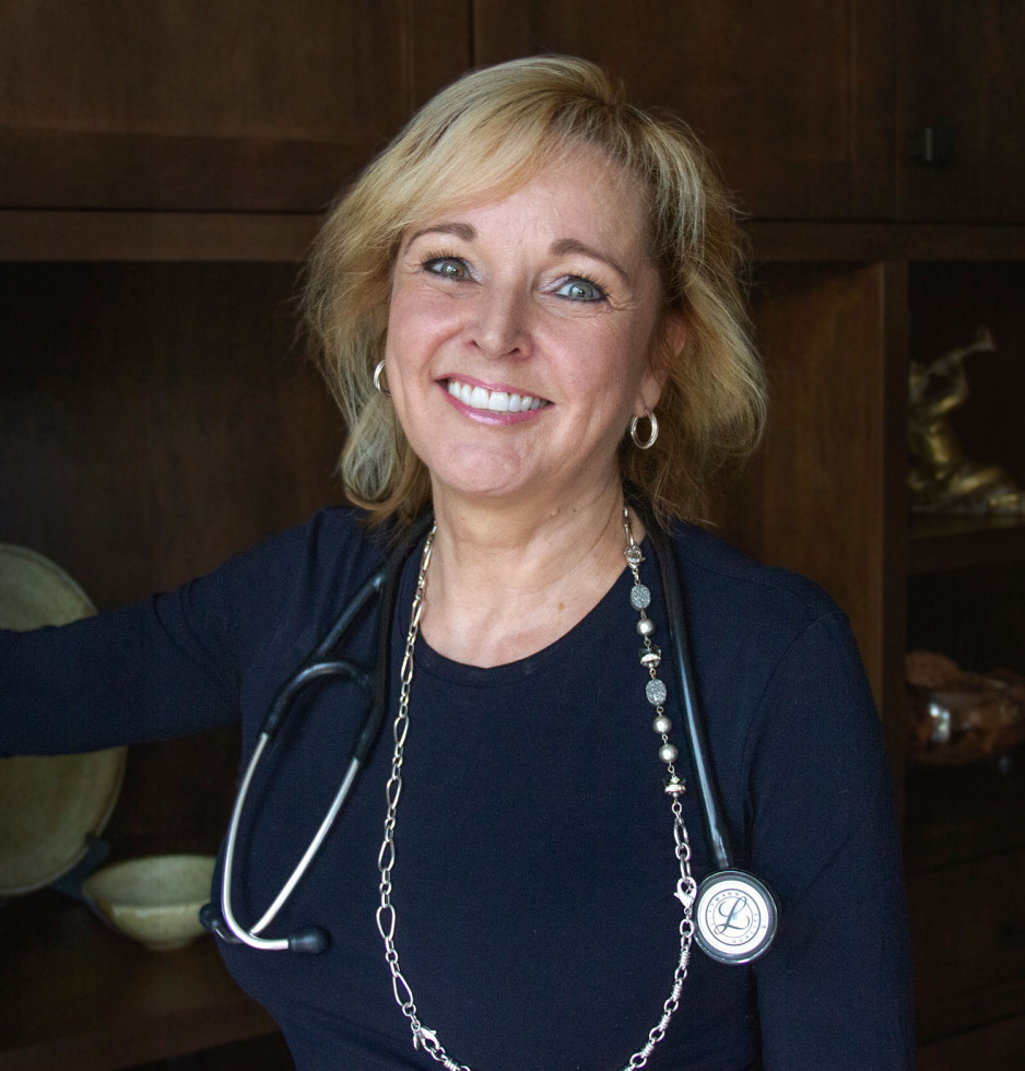 Dr. Laura Lyons wearing a stethoscope and smiling