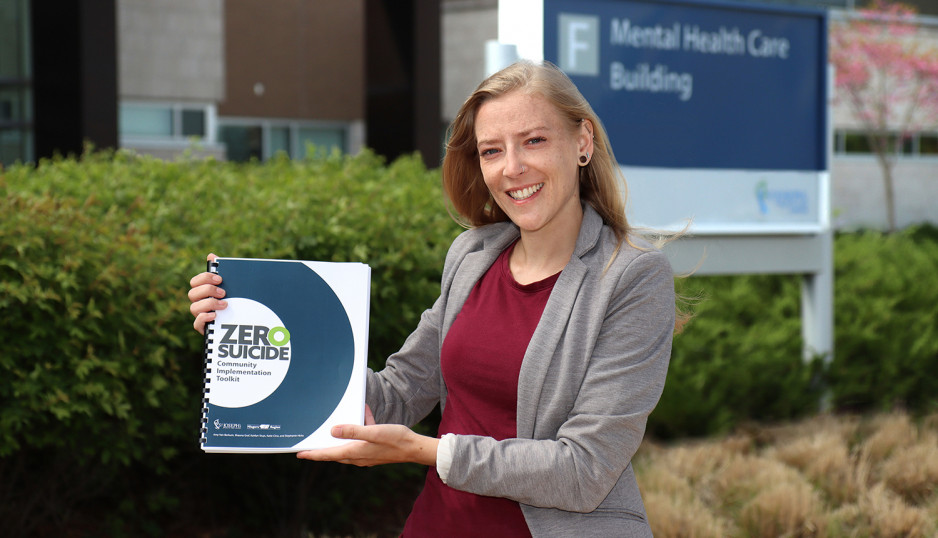 Shauna Graf holding a copy of the Zero Suicide Community Implementation Toolkit