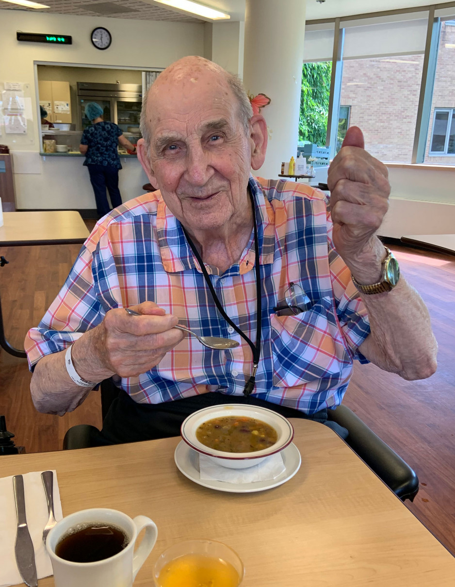 a veteran a Parkwood Institute eating Three Sisters Soup, giving the taste a thumbs up of approval