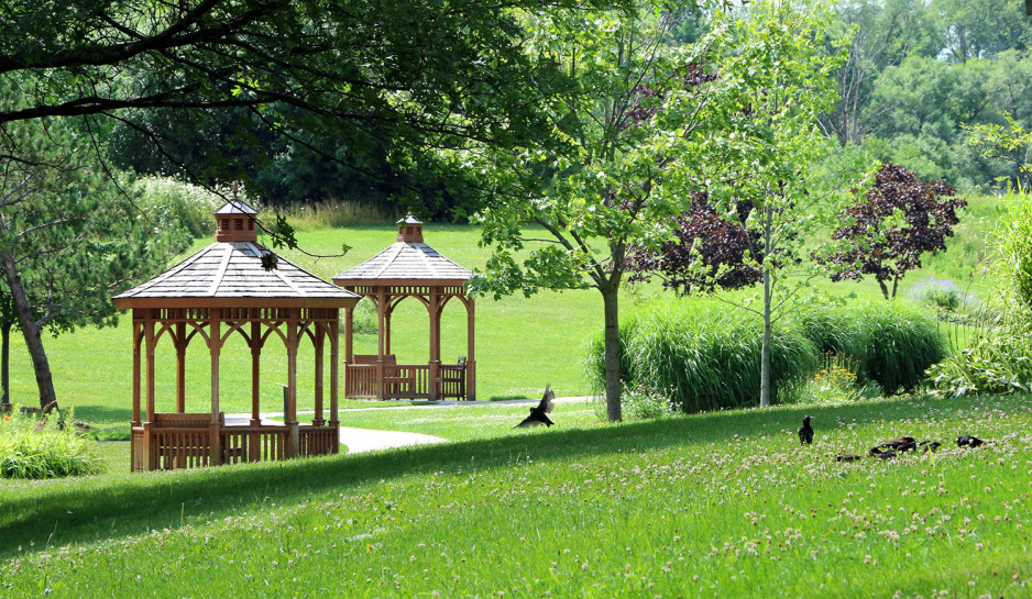 rolling hills with gazebos nestled among a treed setting with birds