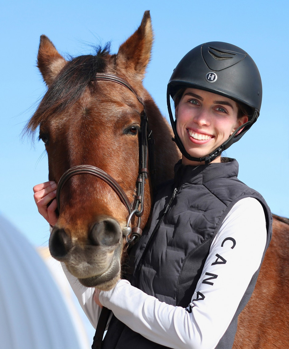 a headshot portrait of Grace Hicks in a riding helmet and her horse Nova