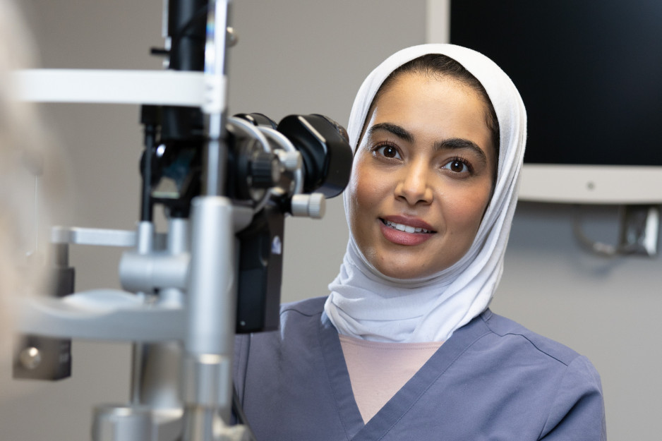 Dr. Fatemah Alali looking beyond a piece of medical equipment