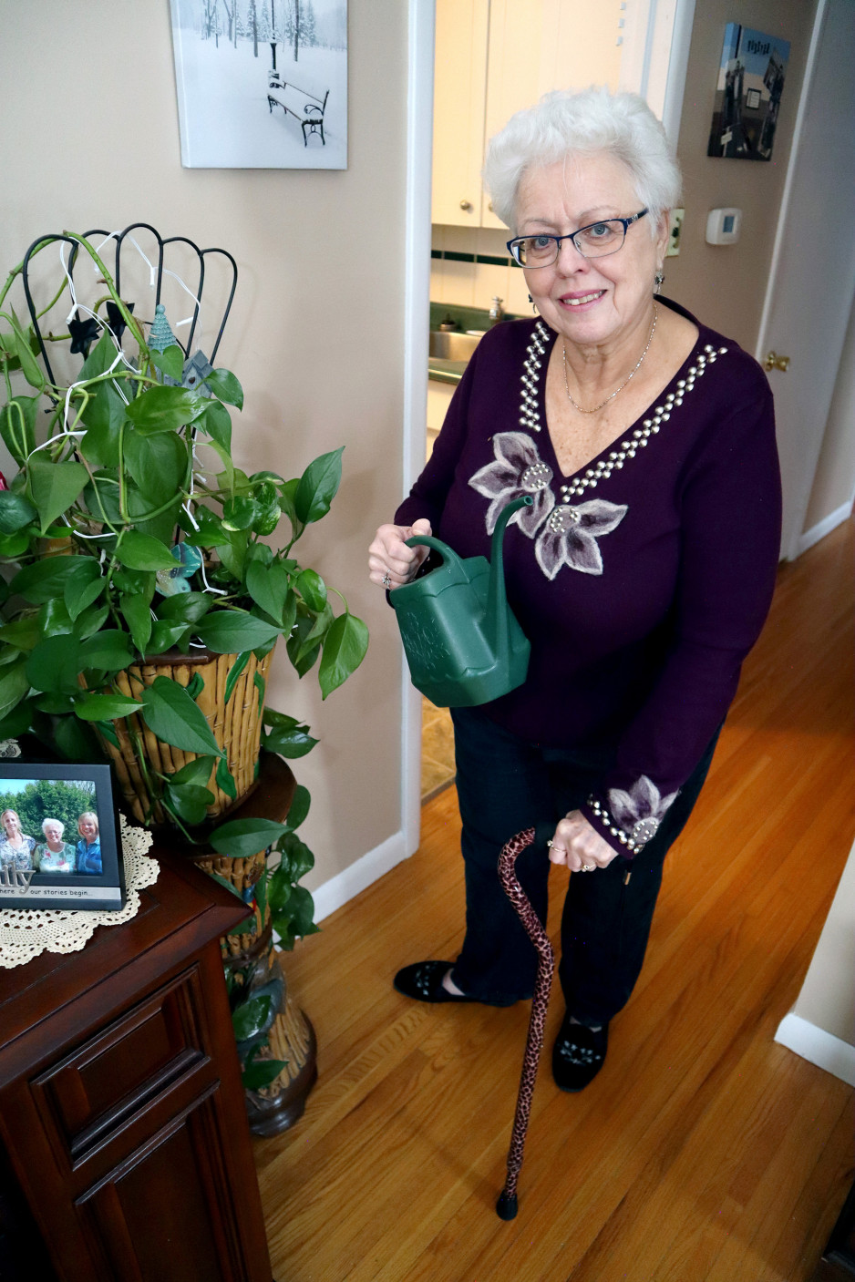 Lynda Vanderaa in her home watering her plants.