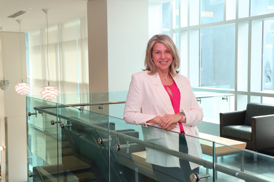 A woman (Tricia) leaning up against a glass railing