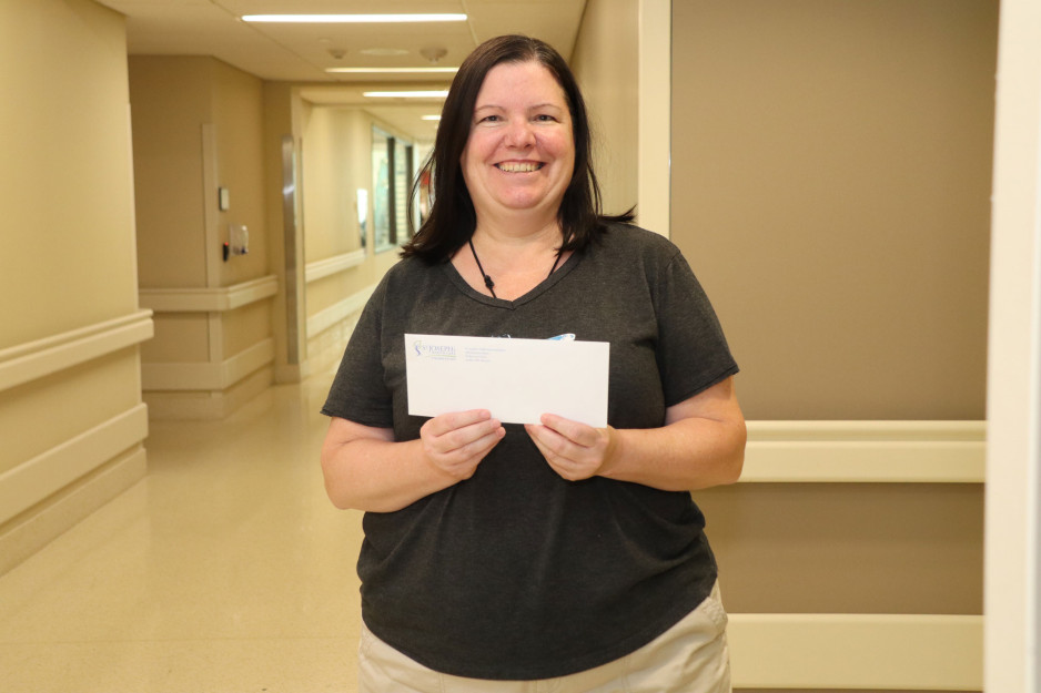 Tara Smith holds up a cheque