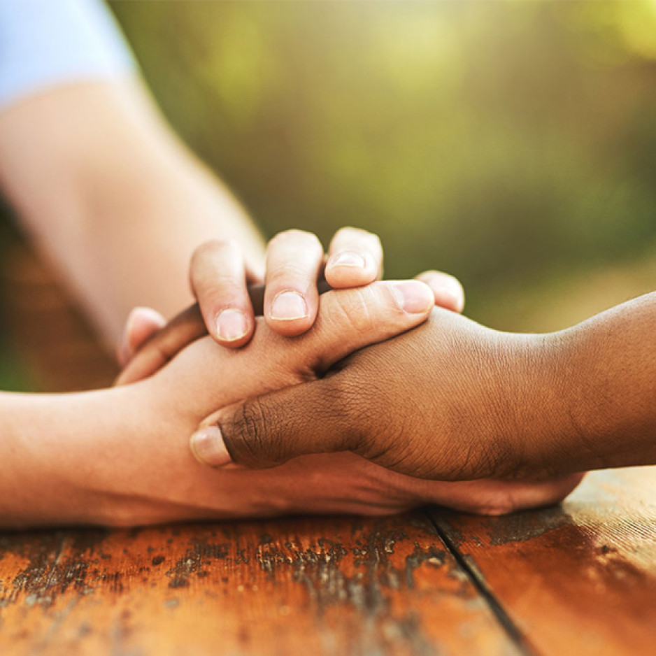 Two hands holding another person's hand