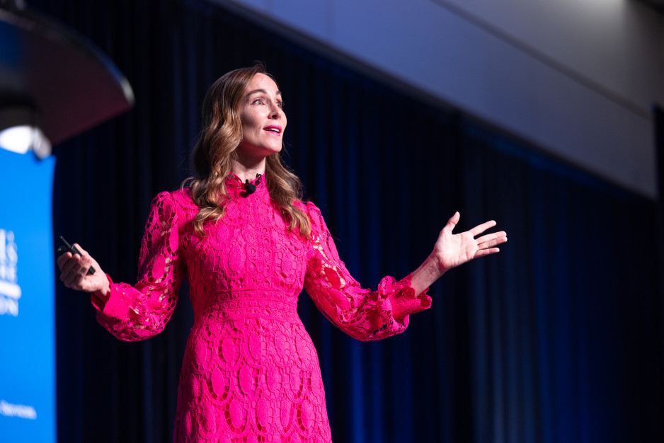 Woman in pink dress presenting on stage