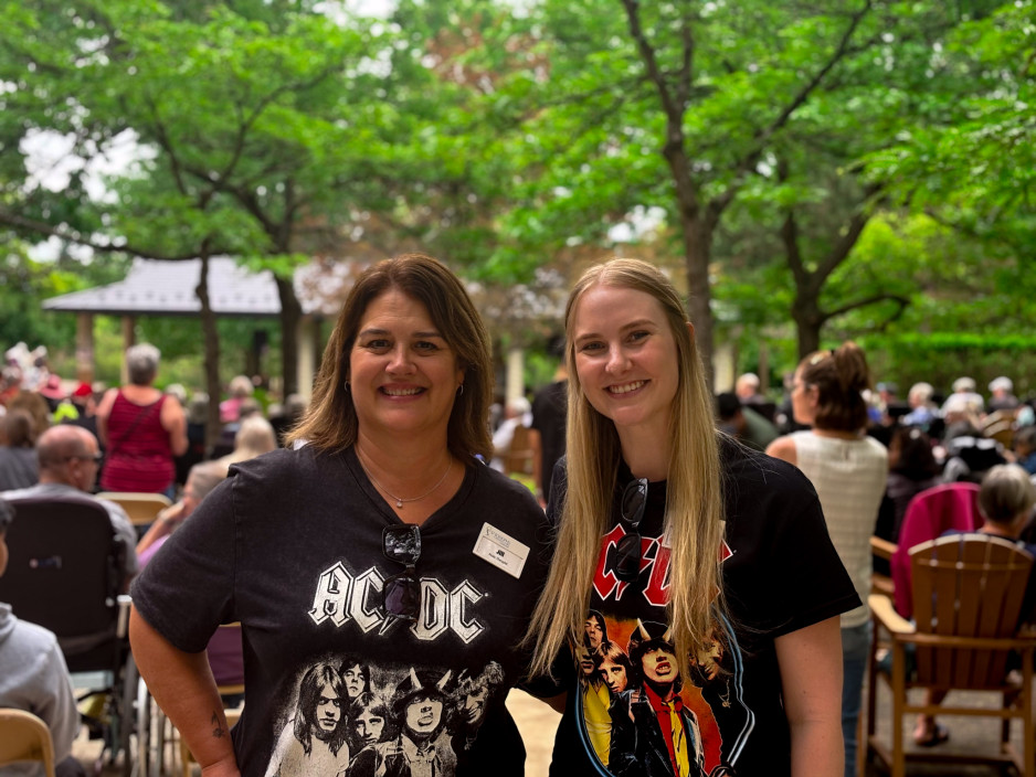 Two care providers in their rock and roll t-shirts smile